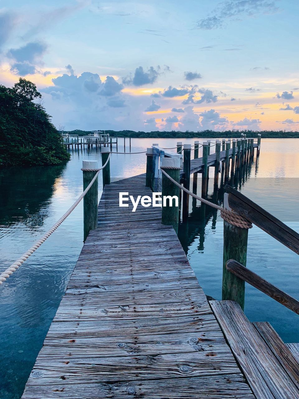 Pier over sea against sky during sunset