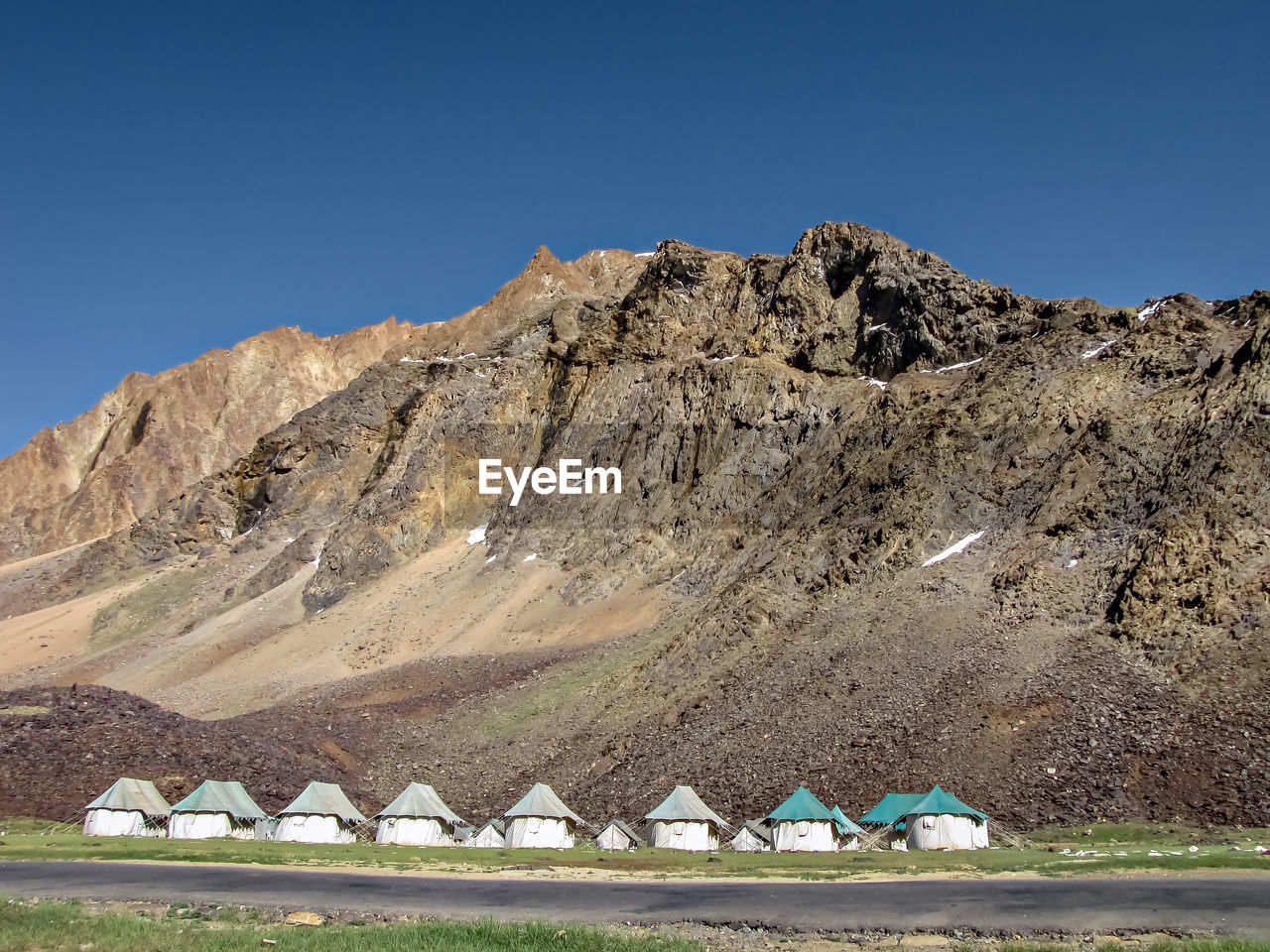 Tents for on way stay accommodation in sarchu , with mountain and sky in background.