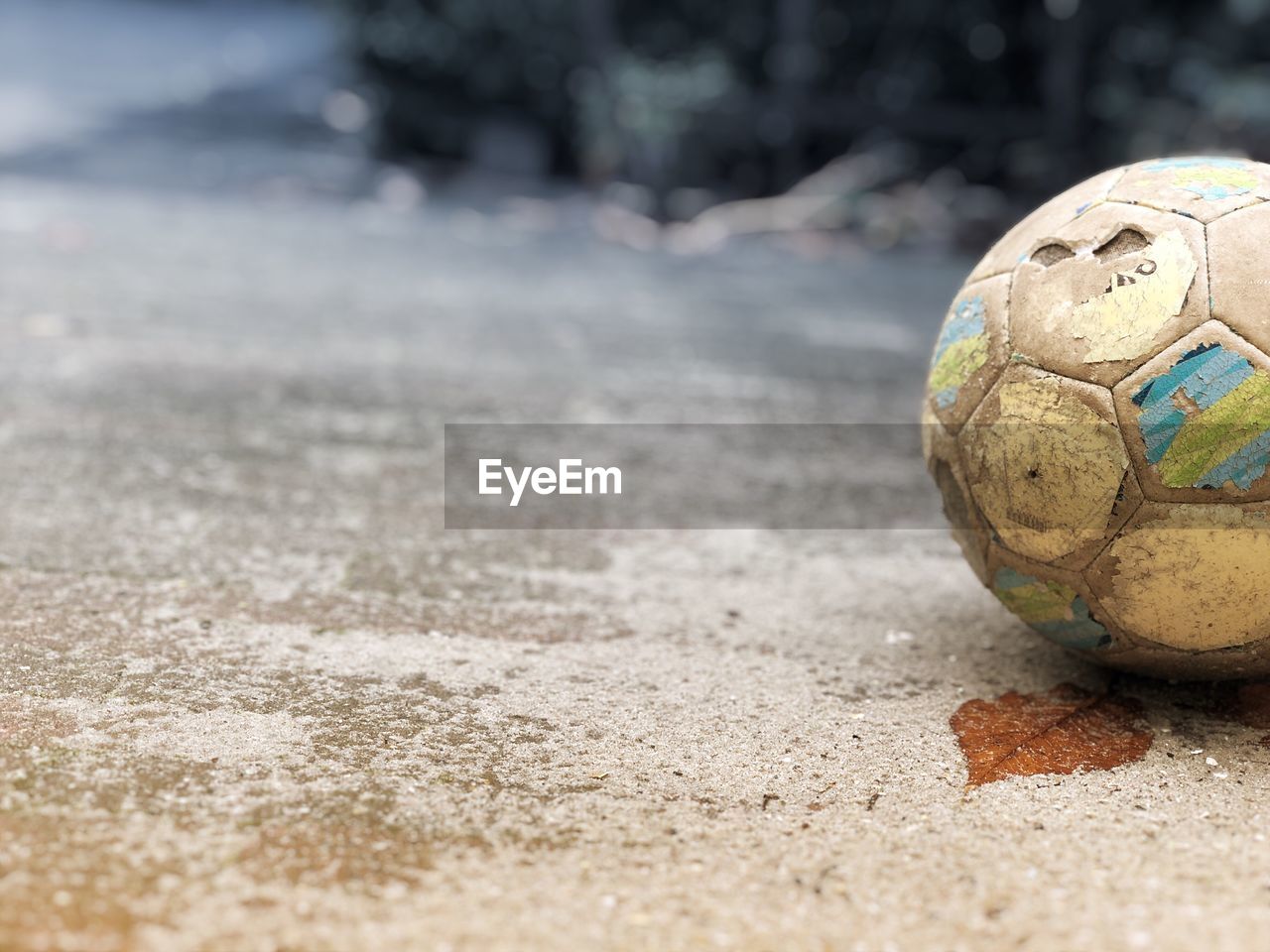 Close-up of abandoned soccer ball on road