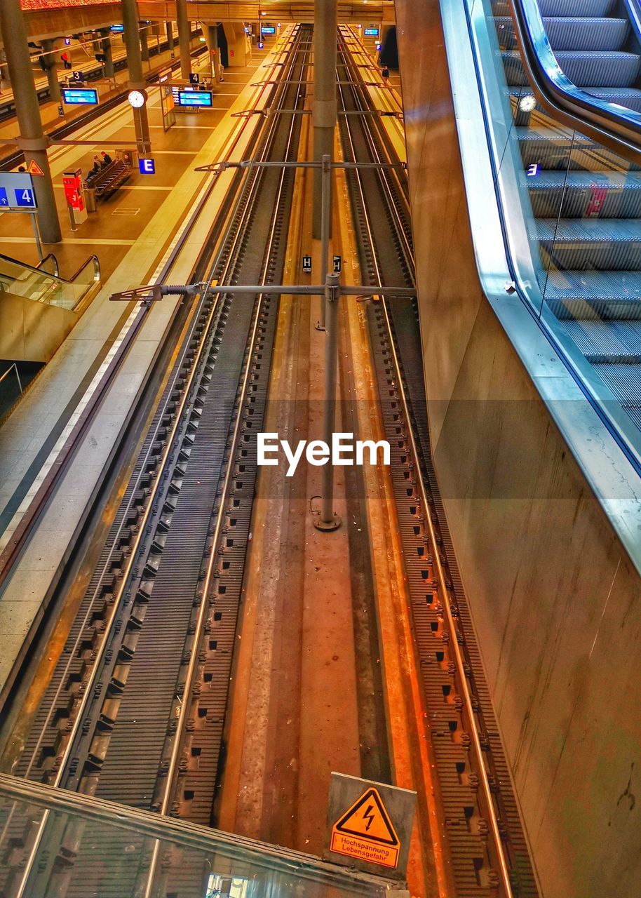 HIGH ANGLE VIEW OF RAILROAD TRACKS AT STATION PLATFORM