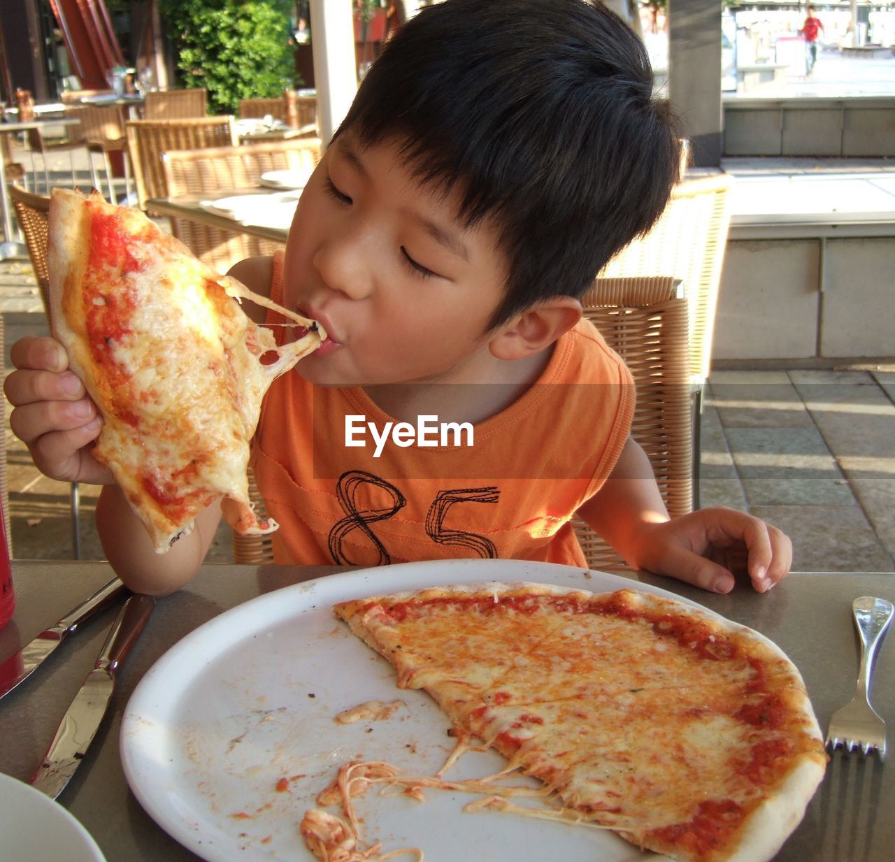 Boy eating pizza at restaurant