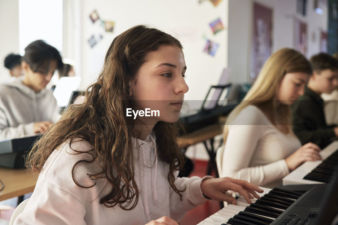 Teenagers attending keyboard lesson