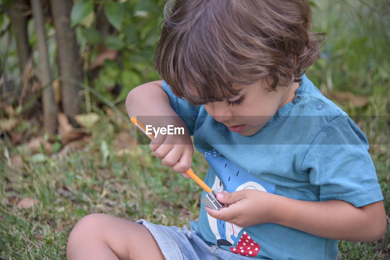 Elementary school age boys love to paint in parks. boys are drawing pictures as an outdoor hobby.