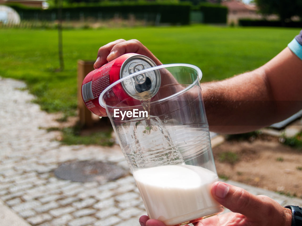 CLOSE-UP OF HAND HOLDING DRINK WITH GLASS