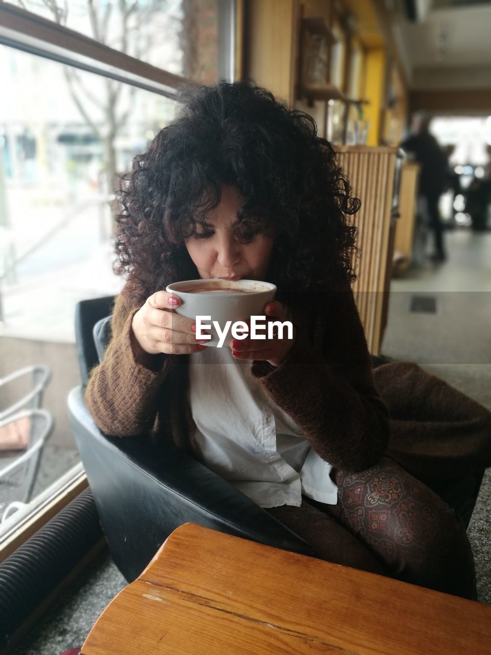 Woman drinking coffee at cafe