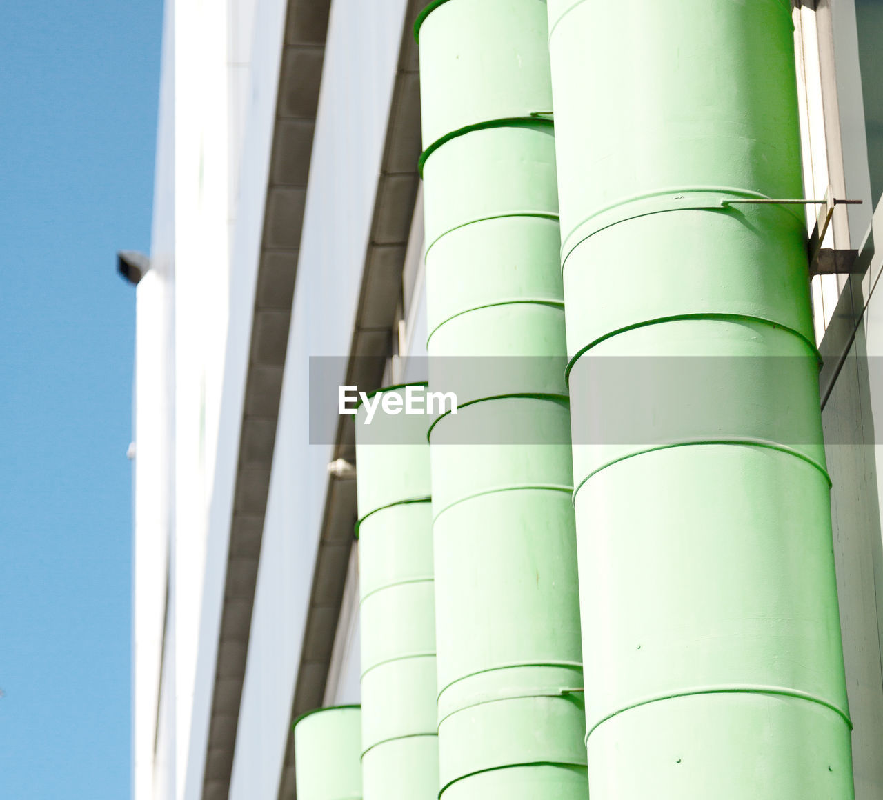 LOW ANGLE VIEW OF PIPES IN FACTORY AGAINST SKY