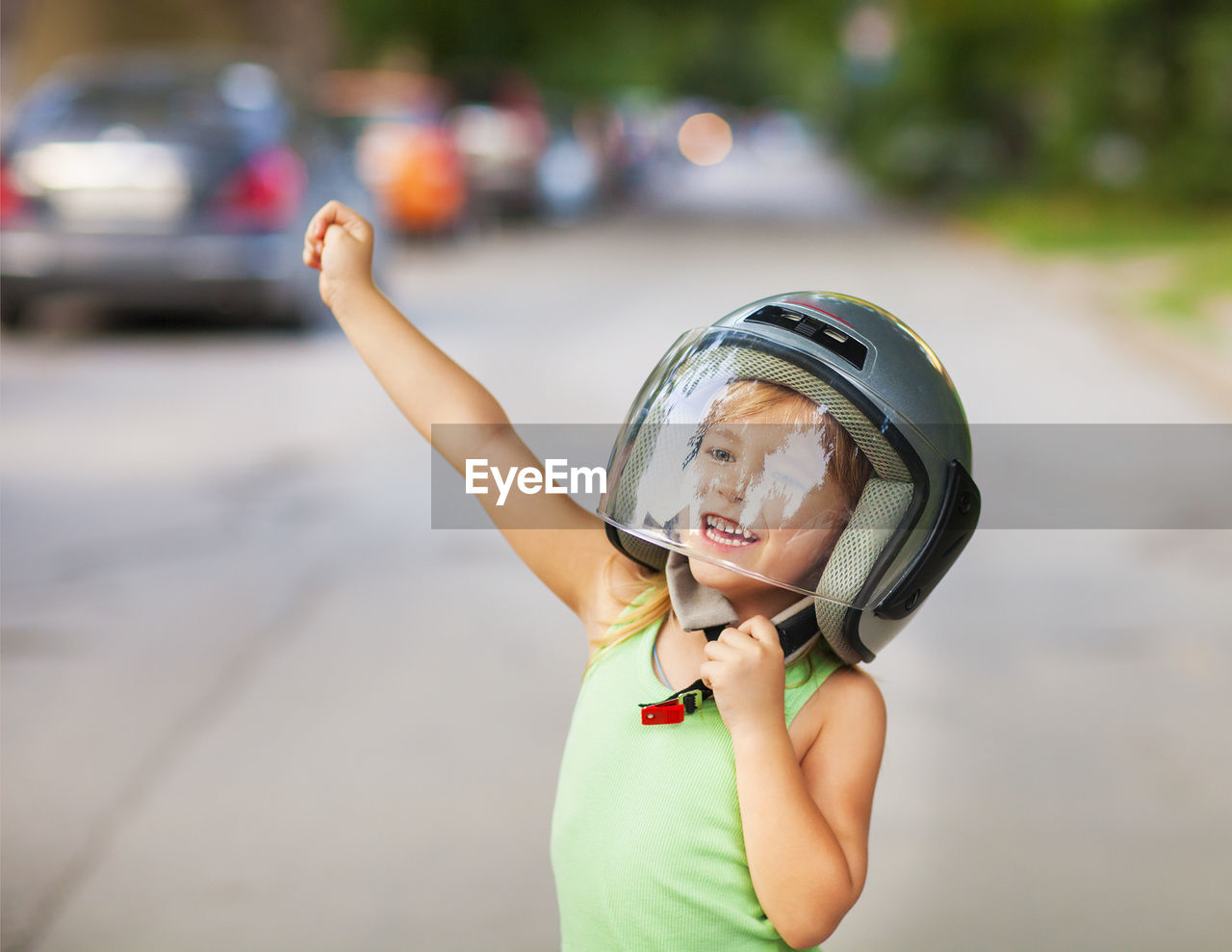 Cheerful girl wearing helmet outdoors