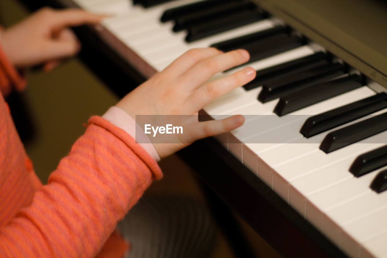 Cropped hands of boy playing piano