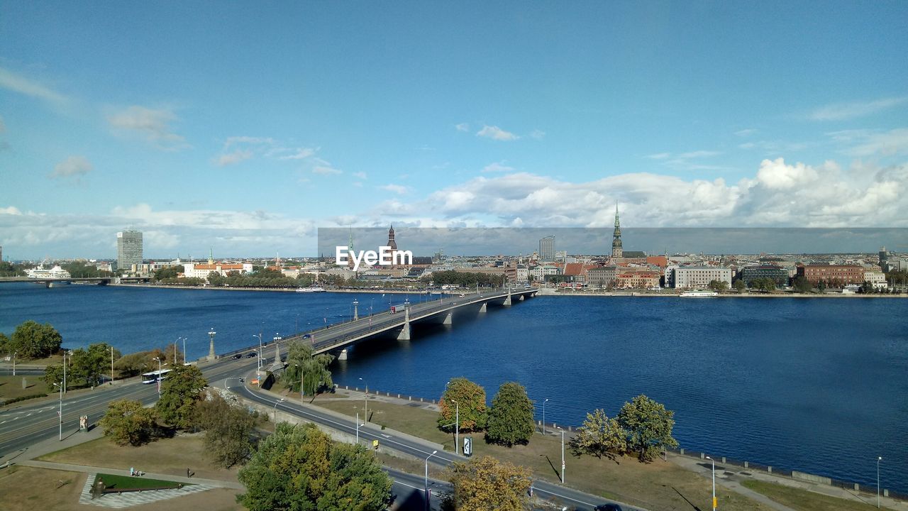 Bridge over river in city against sky