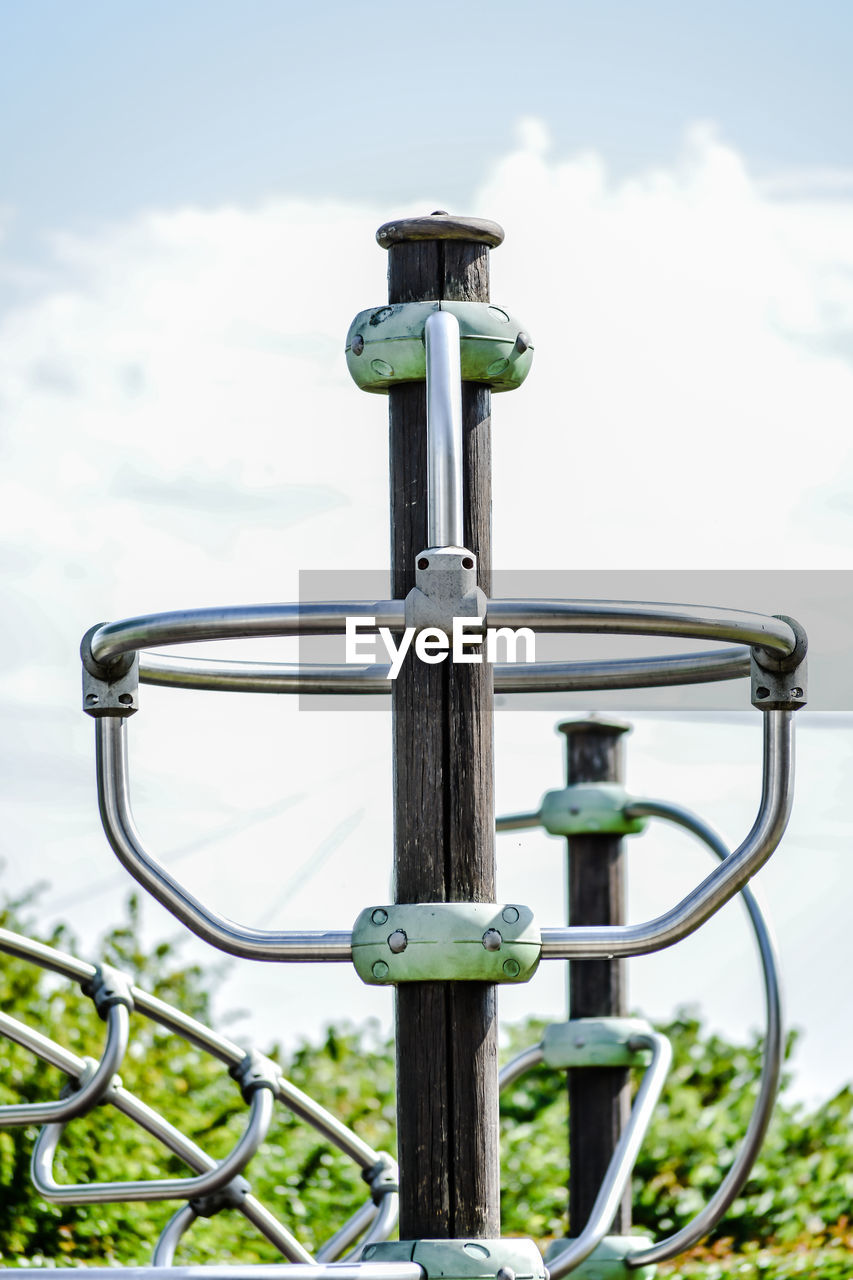 Low angle view of metal fence against sky