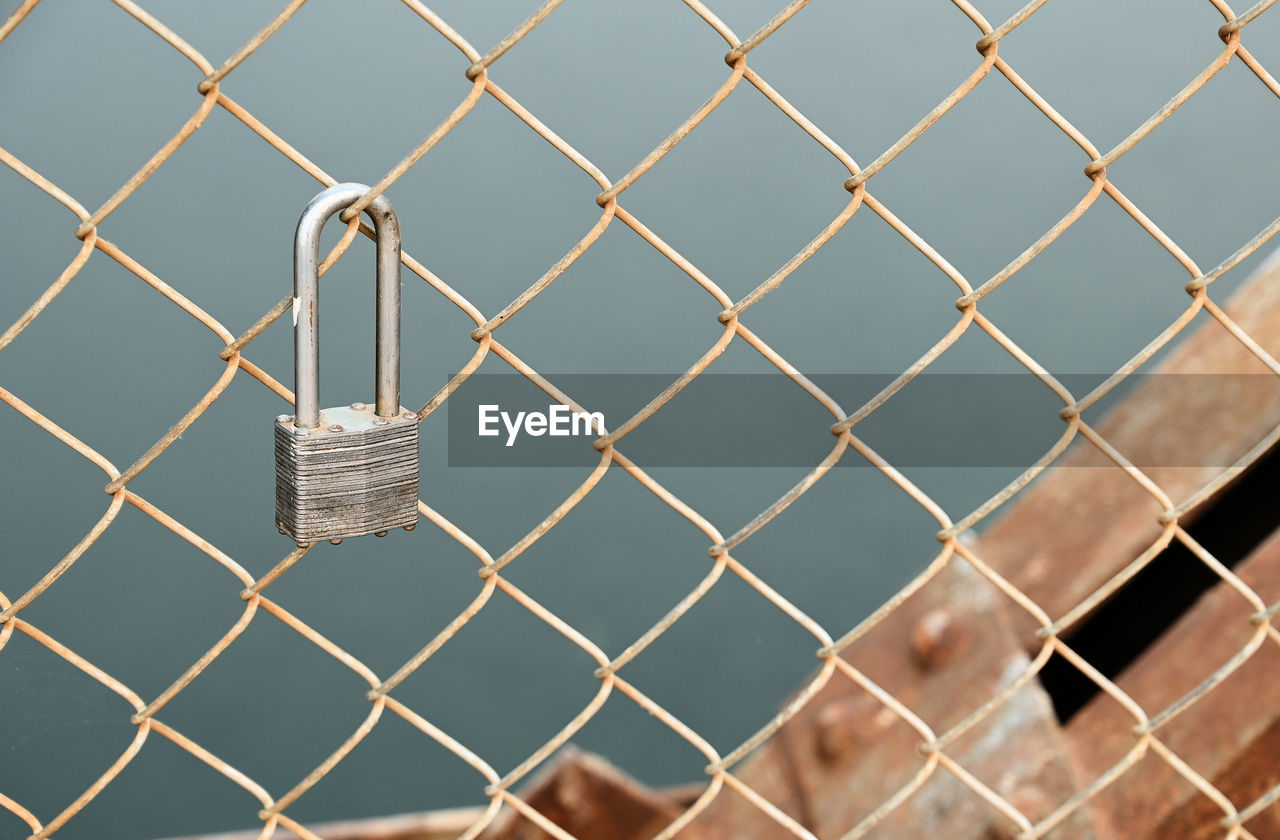 CLOSE-UP OF PADLOCK ON FENCE