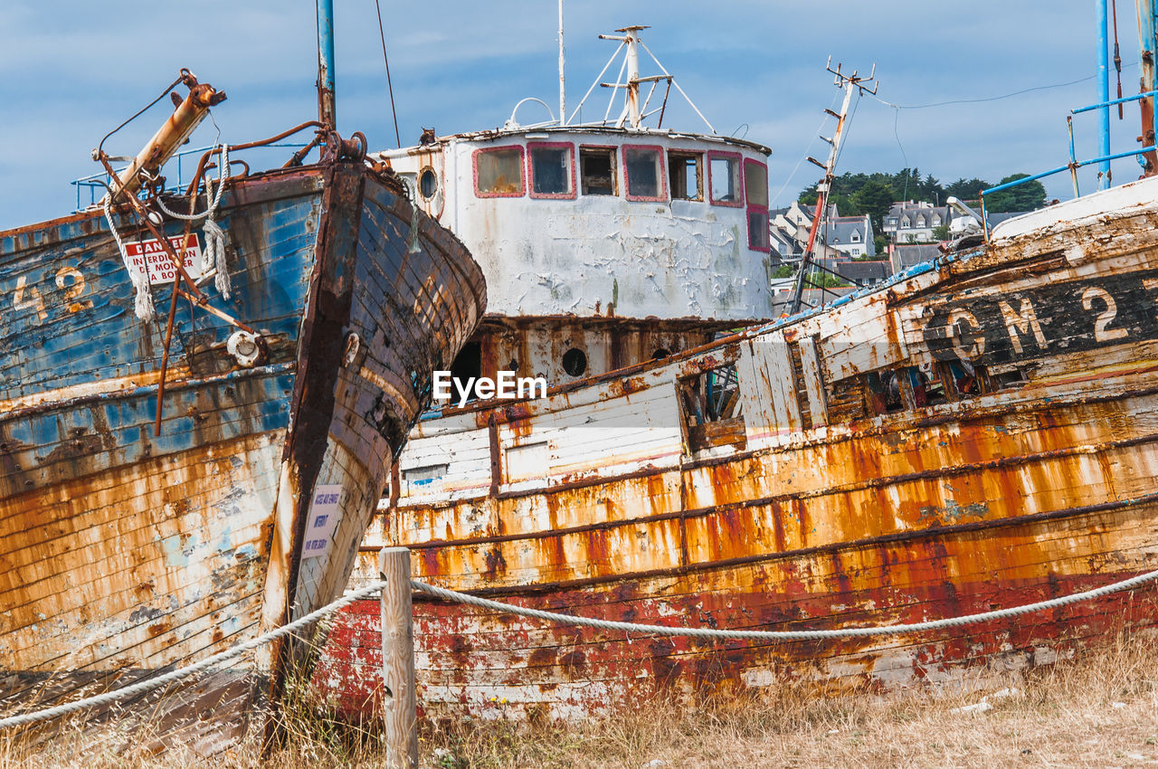 OLD RUSTY SHIP MOORED AGAINST SKY