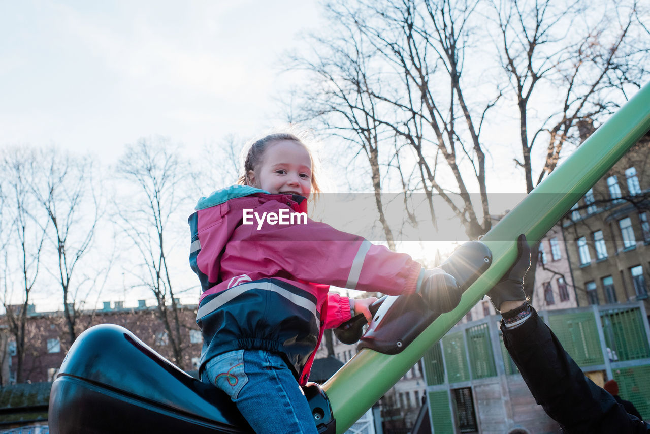 Young girl playing in a park in sweden at sunset with her dad