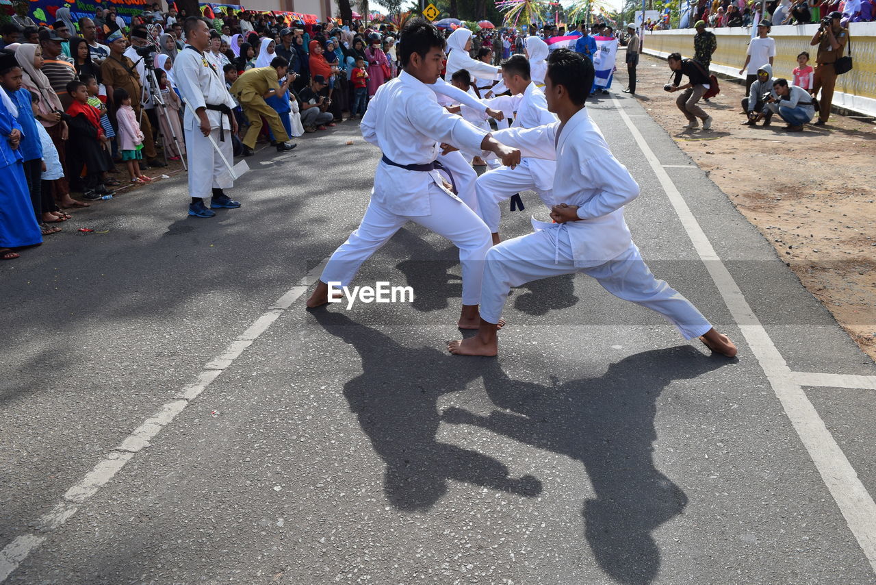 Men practicing karate on road during festival