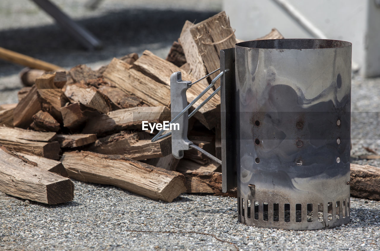 Close-up of camping stove by logs on field