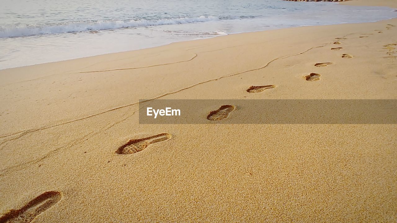 High angle view of footprints on sand at beach