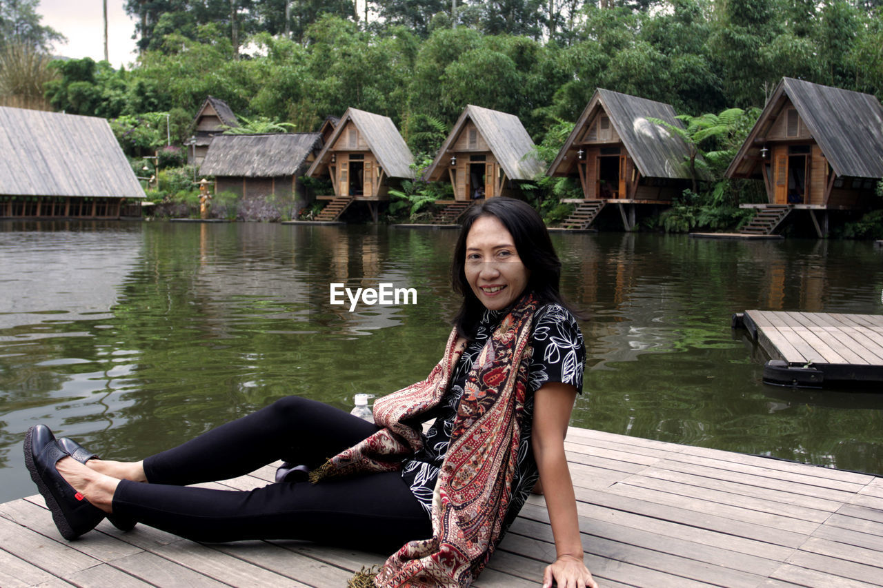 Portrait of woman sitting by lake