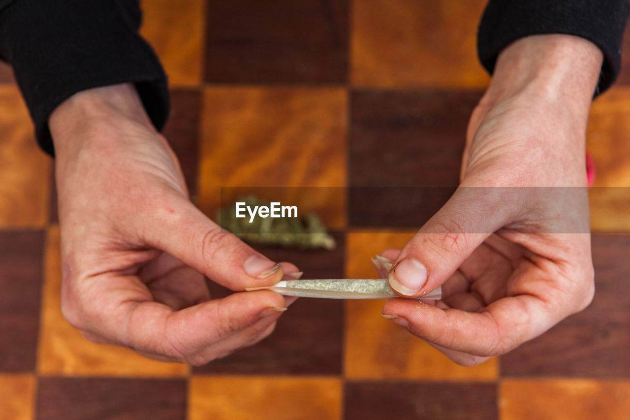 Cropped hand of woman holding marijuana joint