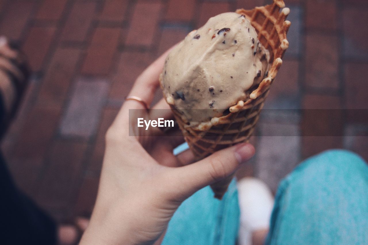 CROPPED IMAGE OF HAND HOLDING ICE CREAM CONE