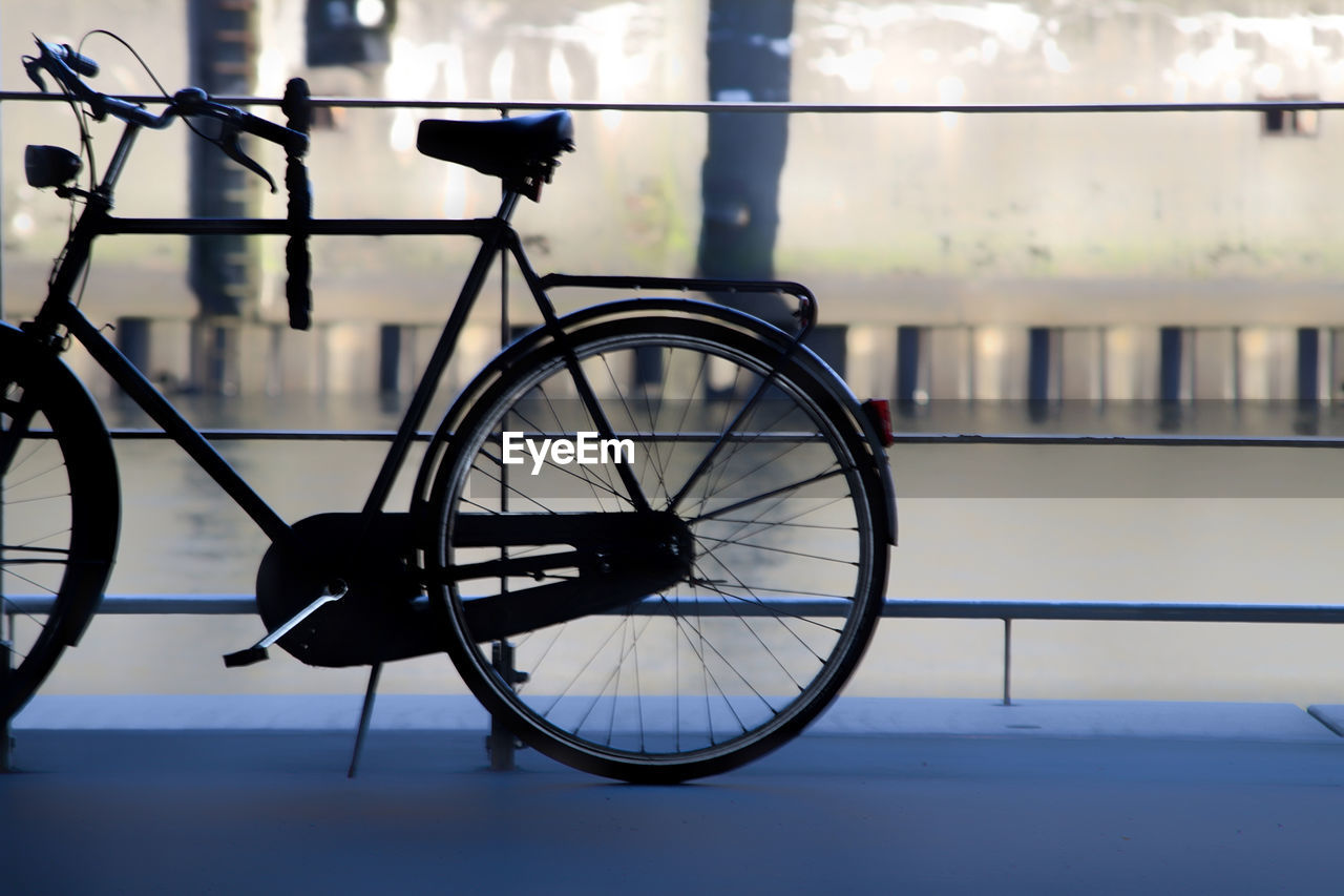 Bicycle parked on bridge over river