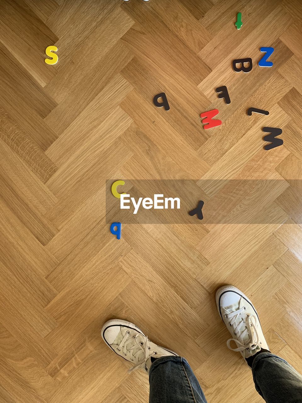 Low section of man with shadow on hardwood floor