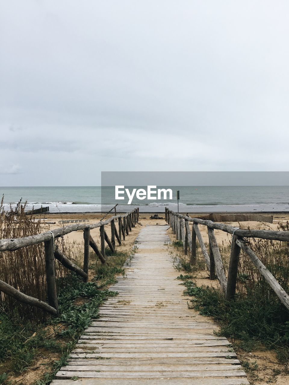 WOODEN PIER ON SEA AGAINST SKY