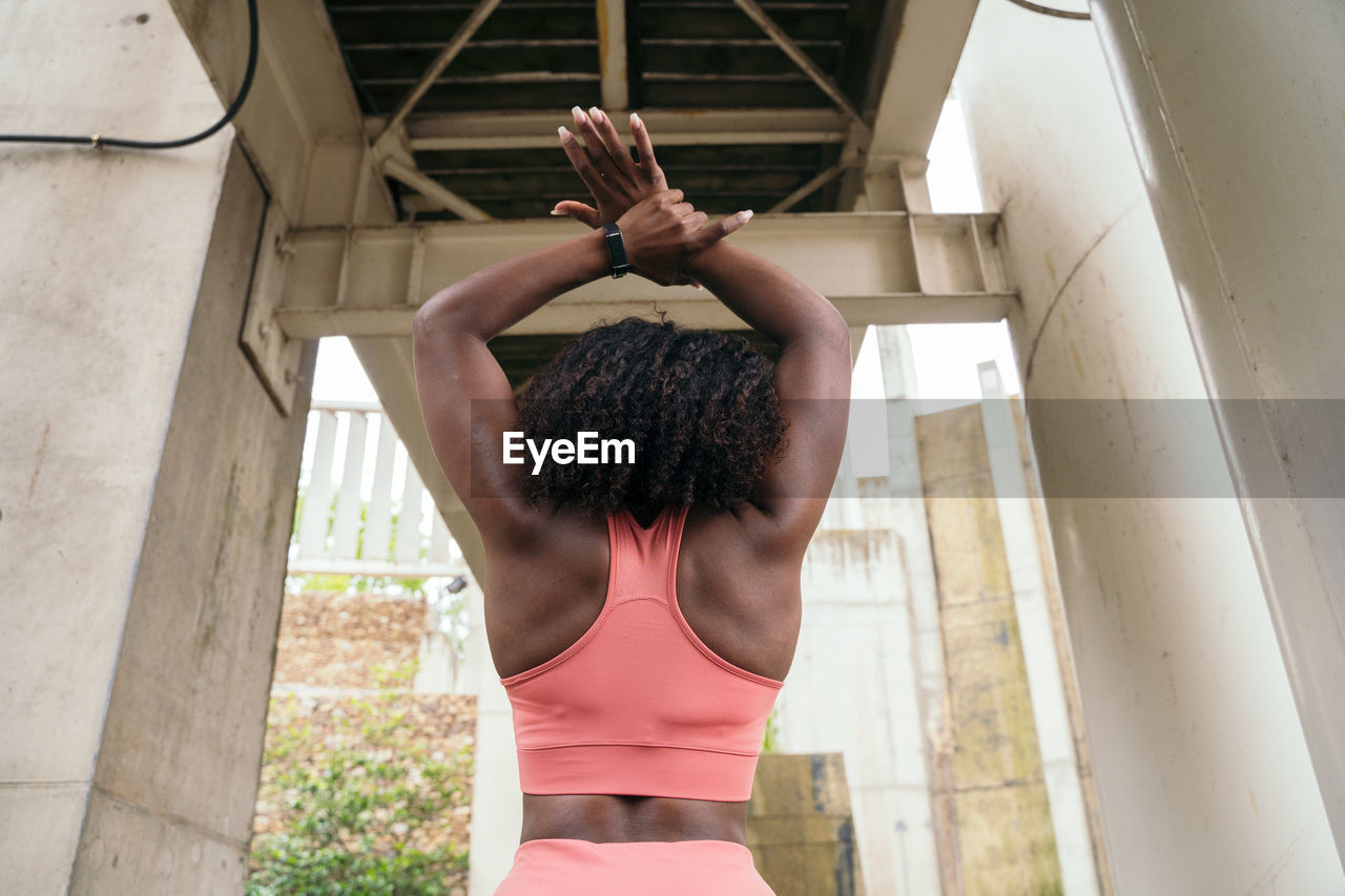 Rear view of woman stretching outdoors