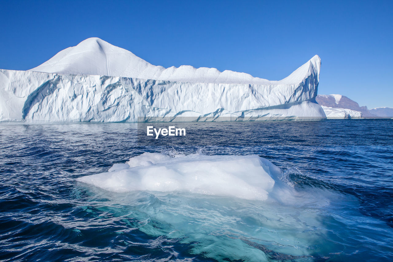 SCENIC VIEW OF SEA AGAINST SNOWCAPPED MOUNTAIN