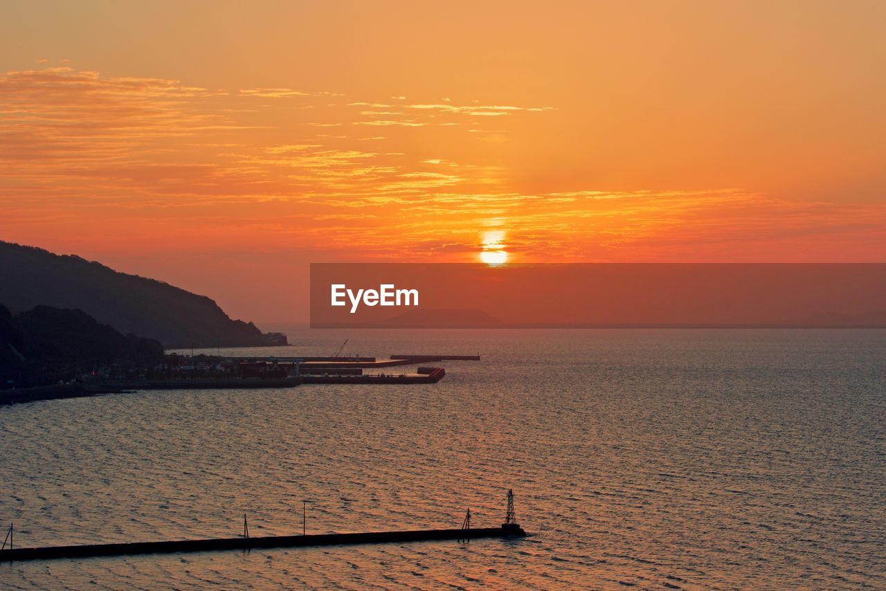 Scenic view of sea against orange sky