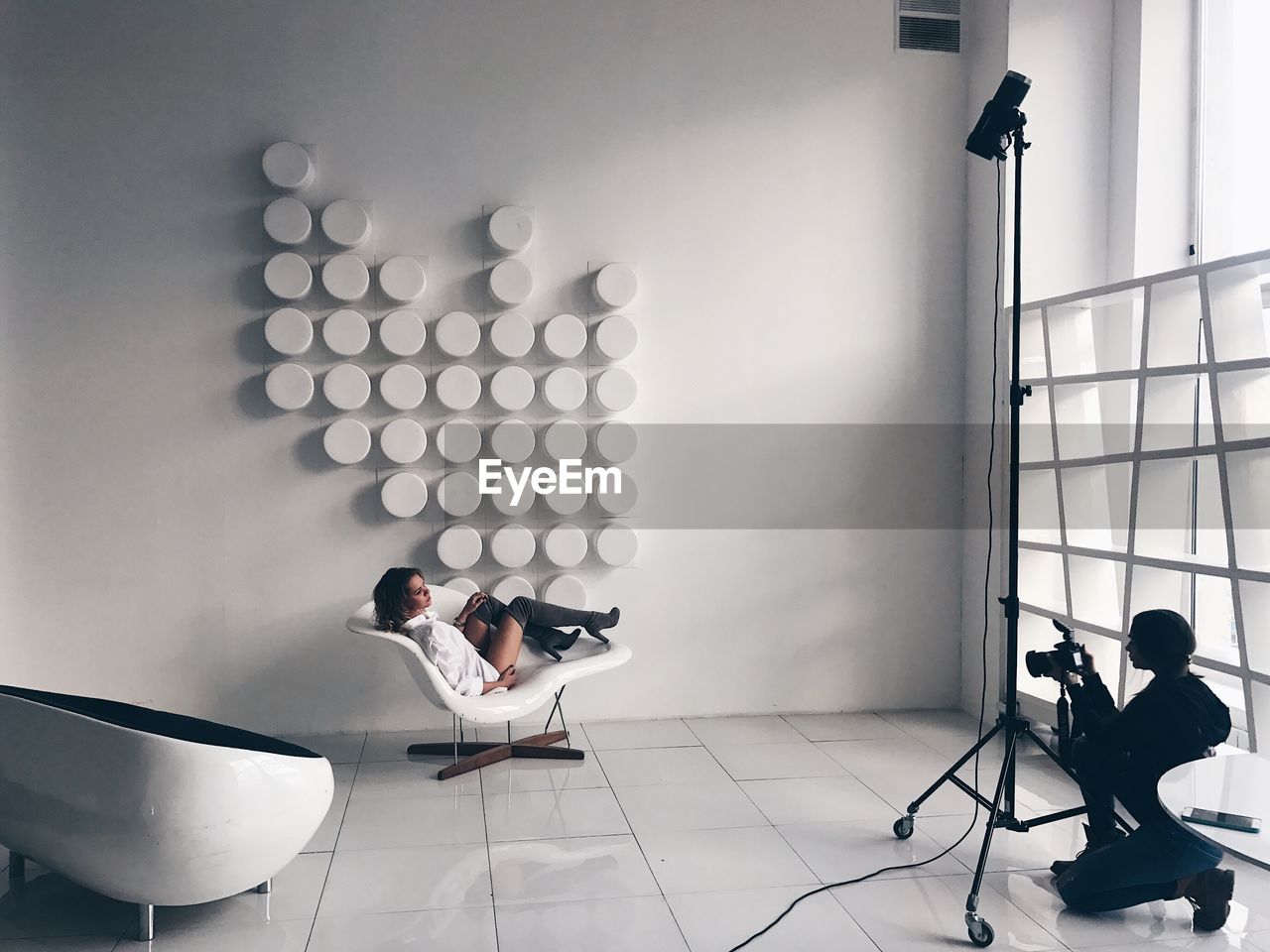 PEOPLE SITTING ON FLOOR AGAINST WALL