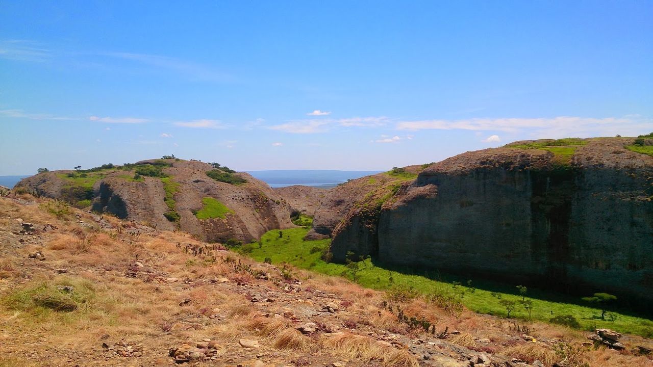 Tranquil view of dramatic landscape against blue sky