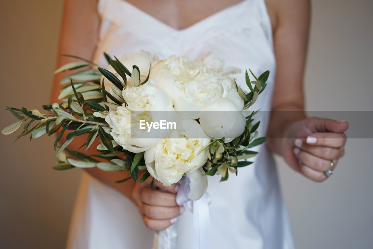 Midsection of bride woman holding wedding flower bouquet