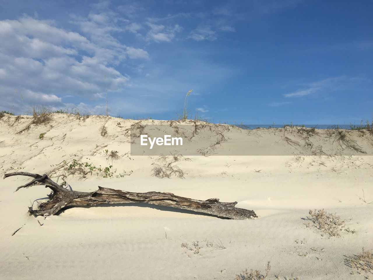 Scenic view of sand dunes against sky