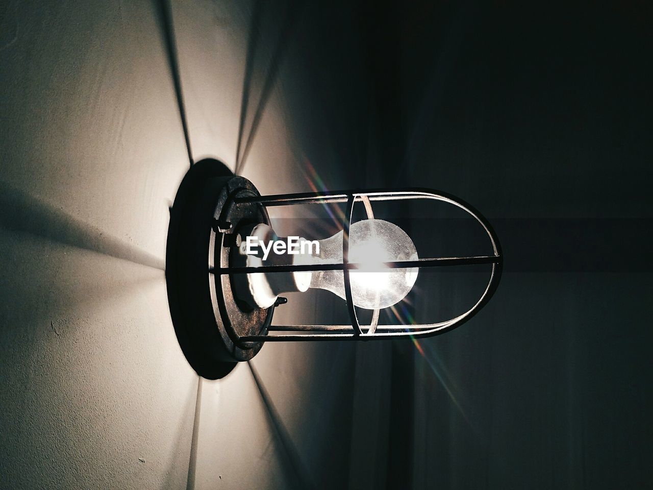 Close-up of illuminated light bulb mounted on wall