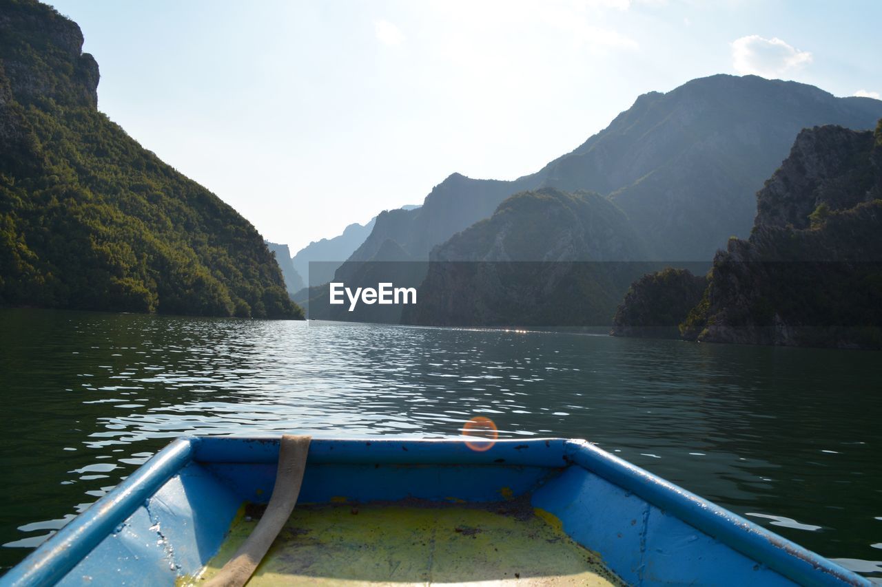 Scenic view of lake by mountains against sky