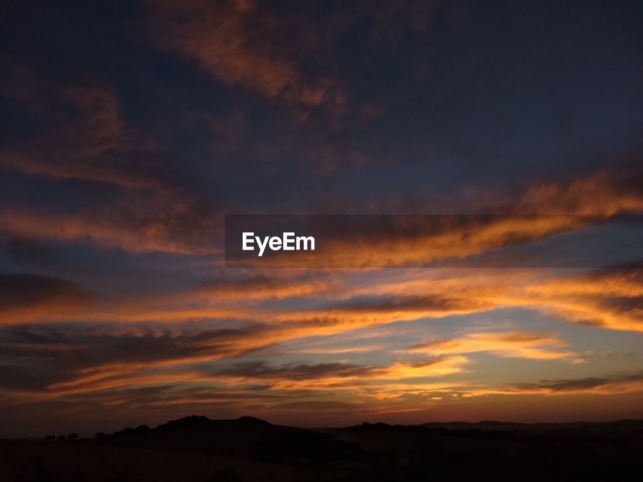 SCENIC VIEW OF SILHOUETTE MOUNTAINS AGAINST DRAMATIC SKY