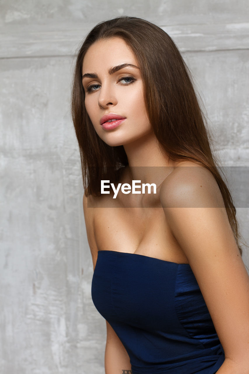 Portrait of beautiful woman against wall