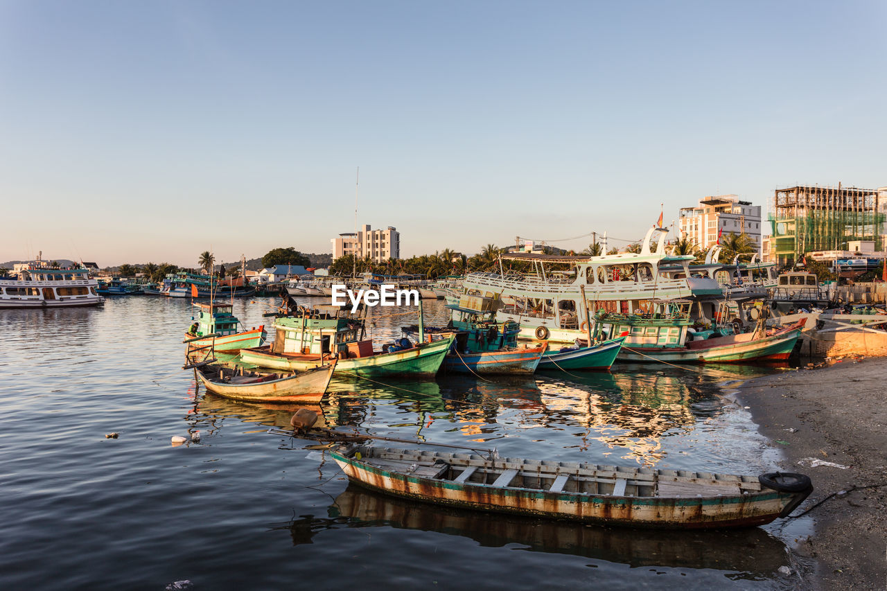 Boats moored in sea against clear sky