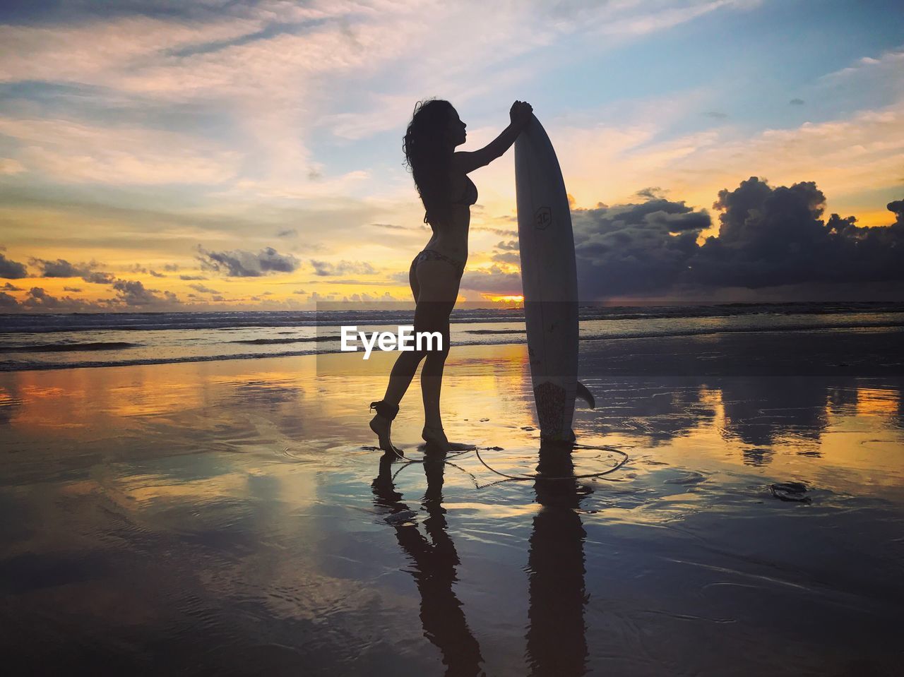 REFLECTION OF MAN ON WOMAN AT BEACH