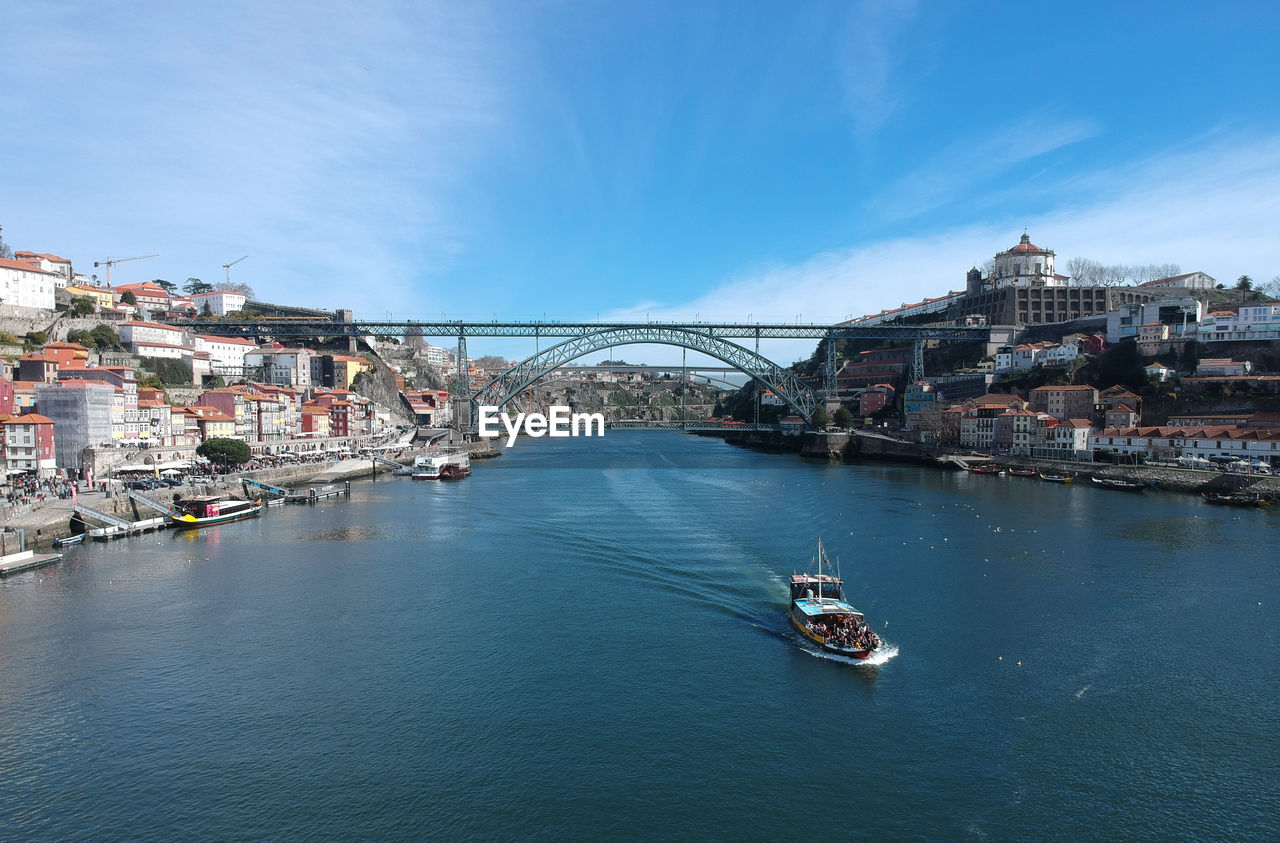 Bridge over river in city against sky