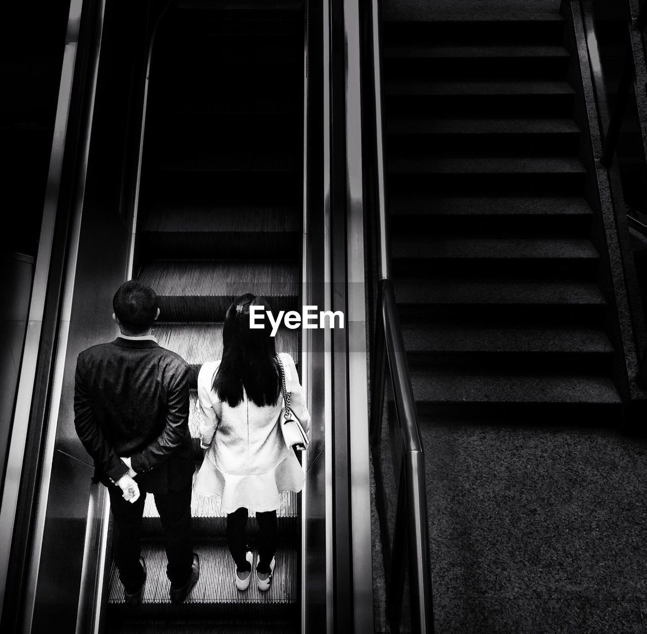 High angle view of man and woman on escalator