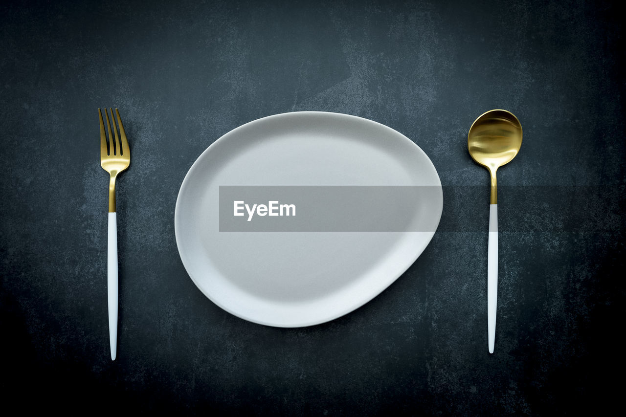 HIGH ANGLE VIEW OF EMPTY TEA AND SPOON ON TABLE