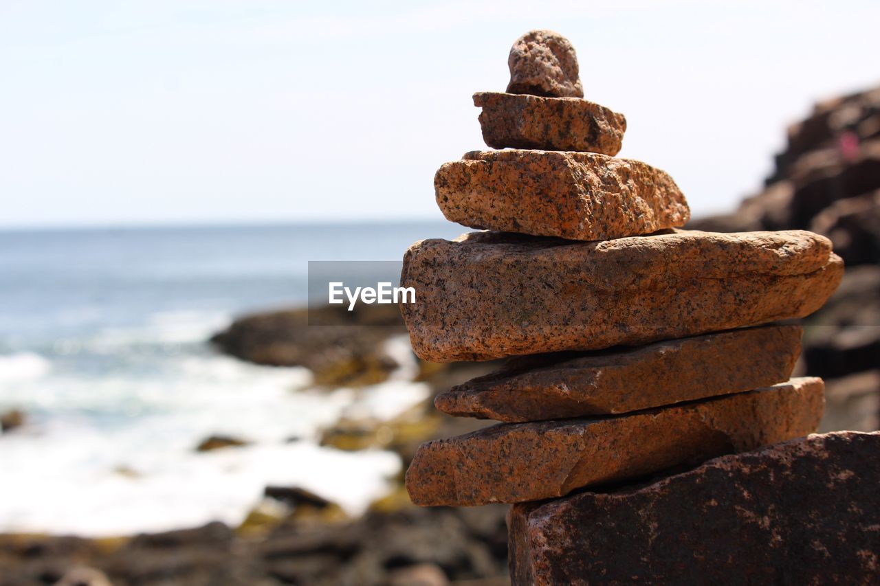 CLOSE-UP OF STACK ON ROCK AT SEA SHORE