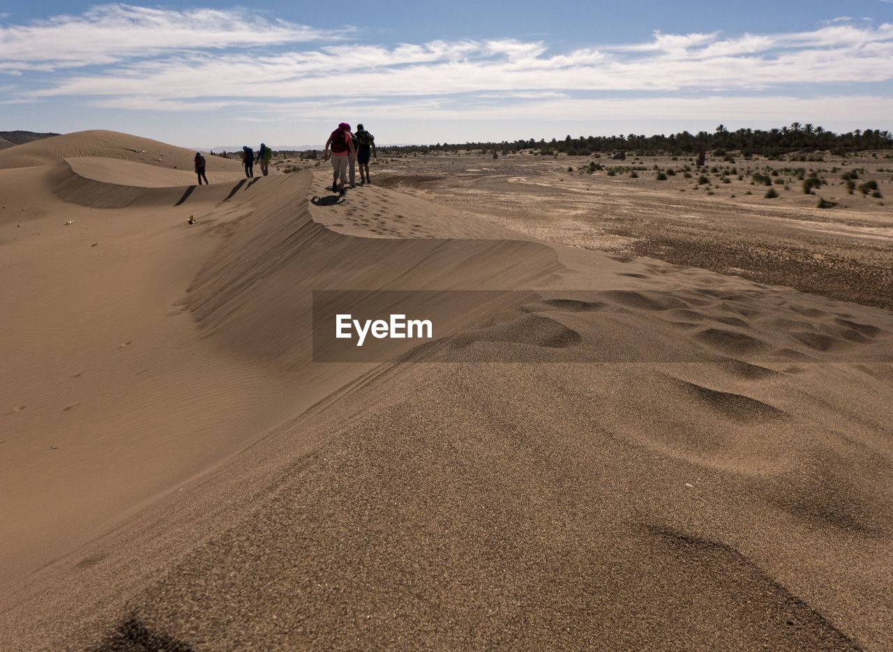 People walking on sand dune in desert