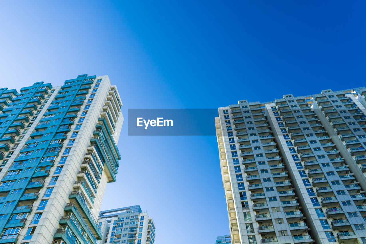 LOW ANGLE VIEW OF BUILDINGS AGAINST CLEAR BLUE SKY