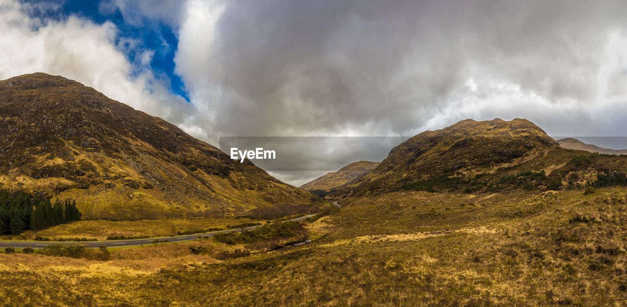 PANORAMIC VIEW OF MOUNTAIN RANGE AGAINST SKY