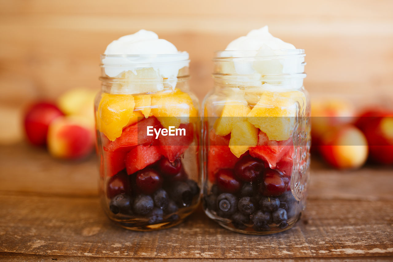 Jars with chopped fruit salad. mango, apple, grapes, blueberries and strawberries, with yogurt. 