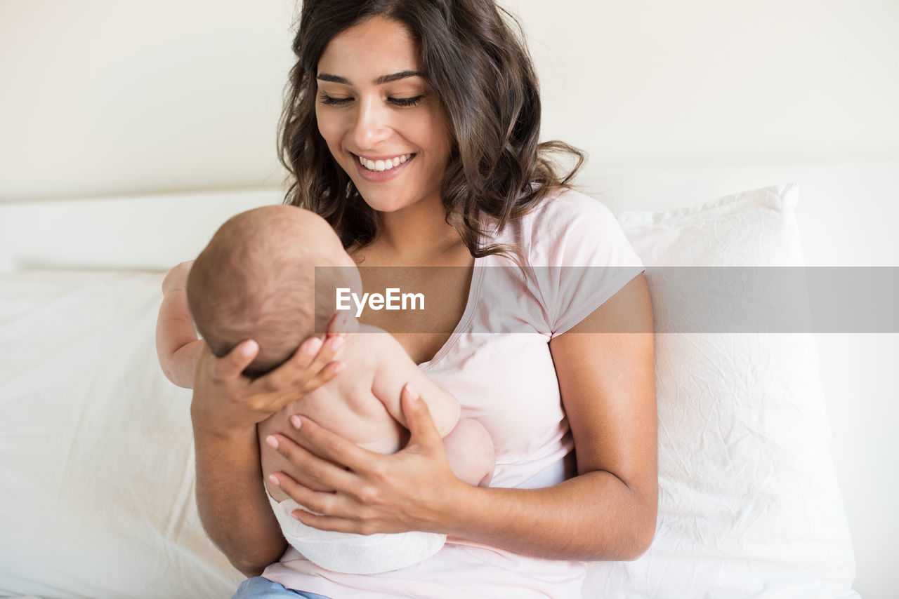 HAPPY MOTHER AND BABY ON BED