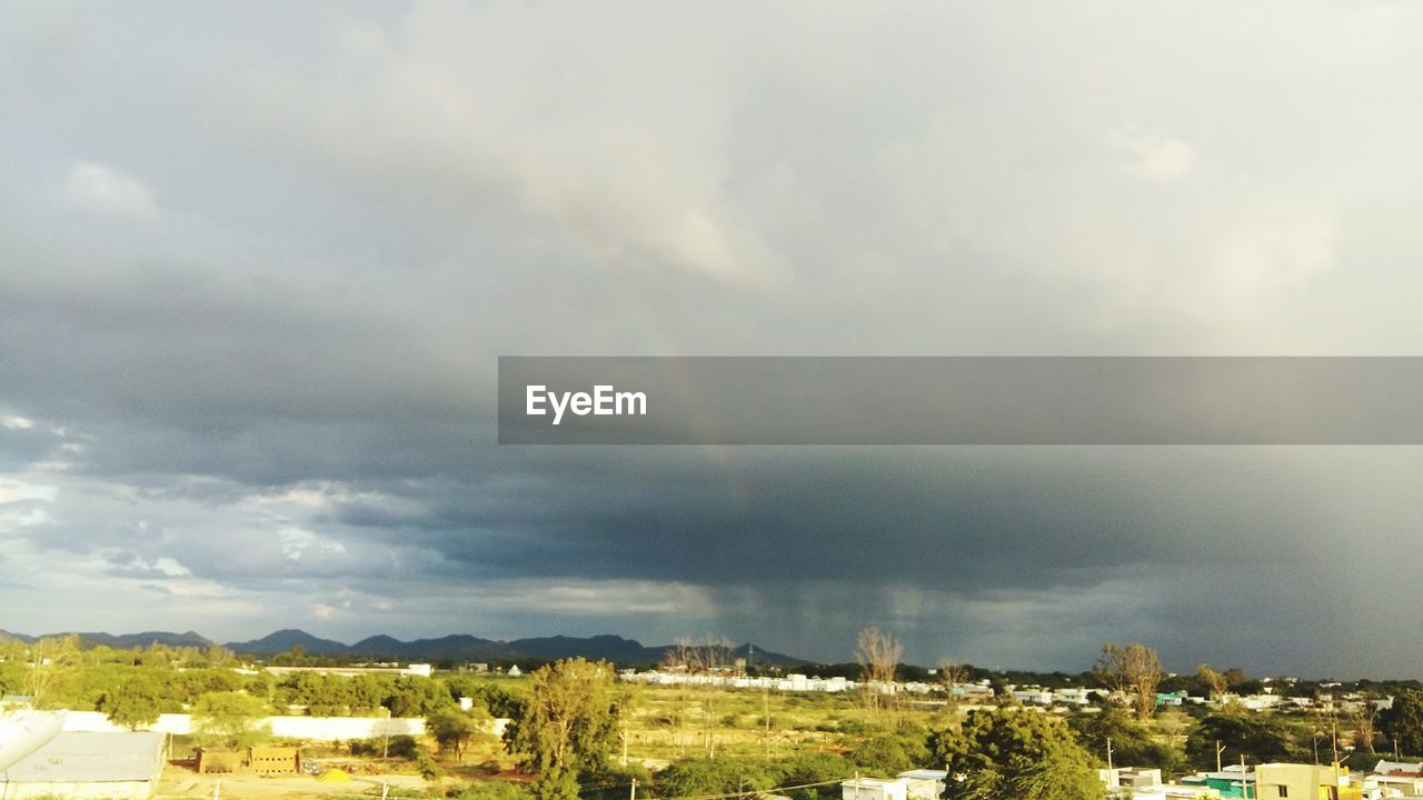 VIEW OF CITYSCAPE AGAINST CLOUDY SKY