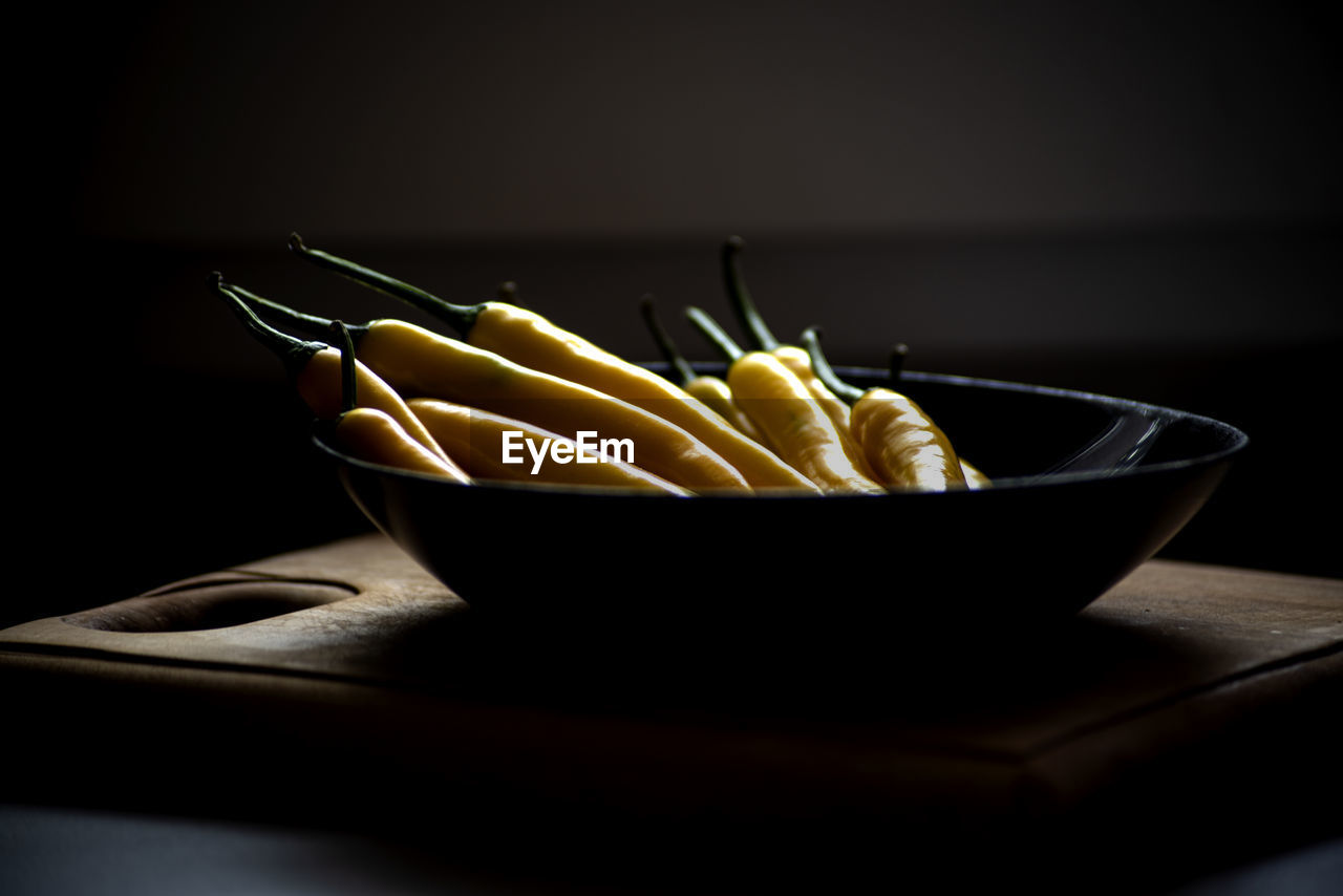 Yellow natural chilli pepper on a black kitchen plate